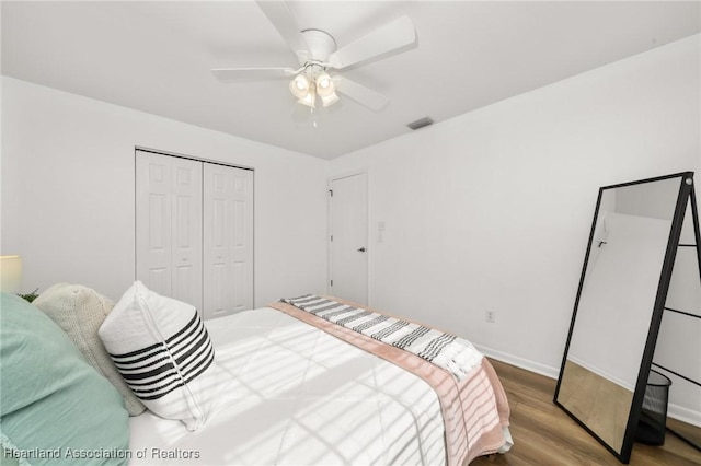 bedroom with hardwood / wood-style flooring, ceiling fan, and a closet