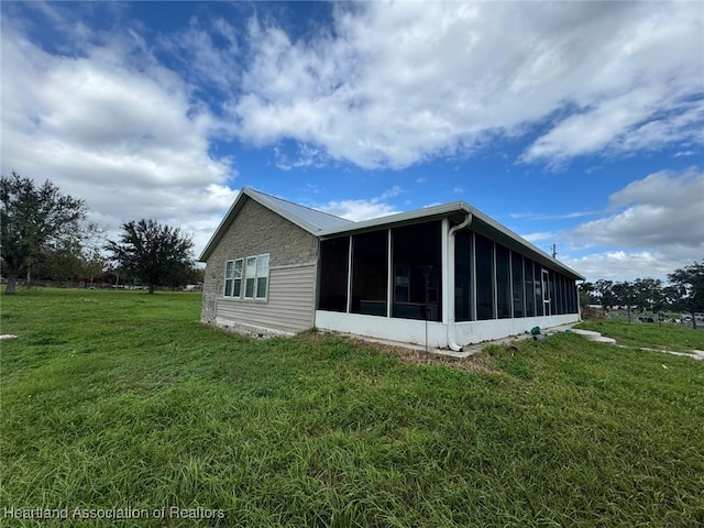 view of side of home with a lawn and a sunroom