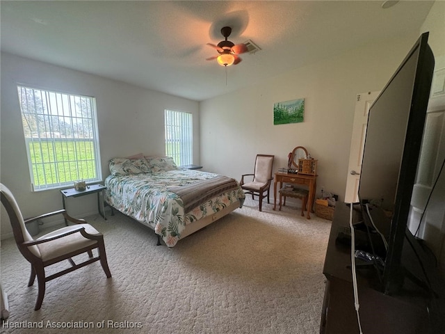 bedroom featuring carpet flooring, multiple windows, and ceiling fan