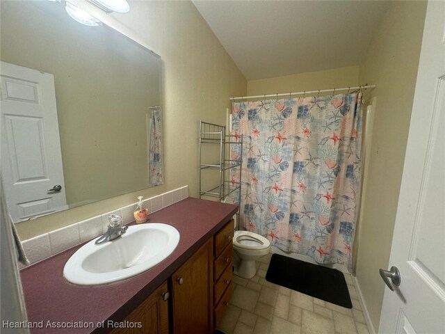 bathroom featuring vanity, toilet, and decorative backsplash