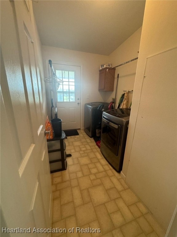 clothes washing area featuring cabinets and washing machine and dryer