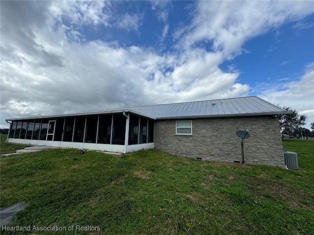 rear view of property with a yard, cooling unit, and a sunroom