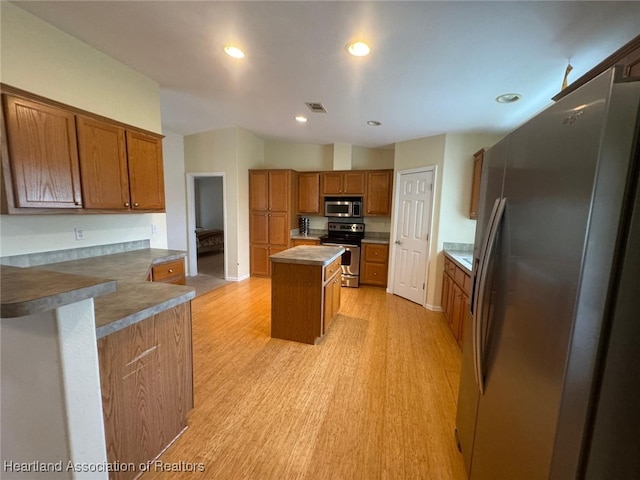 kitchen with a kitchen island, light wood-type flooring, and stainless steel appliances