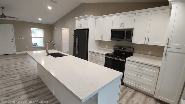 kitchen featuring a center island with sink, black refrigerator with ice dispenser, stainless steel electric stove, and sink