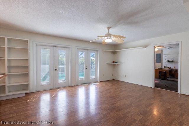 interior space with ceiling fan, wood-type flooring, french doors, a textured ceiling, and electric panel