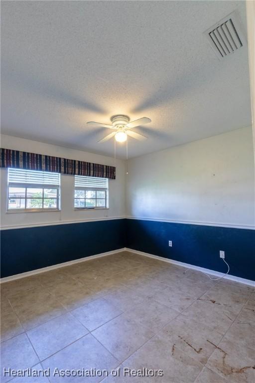 spare room with ceiling fan and a textured ceiling