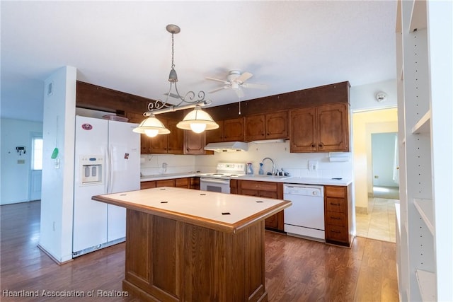 kitchen with white appliances, pendant lighting, a center island, sink, and ceiling fan