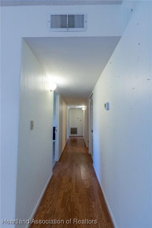 corridor with dark hardwood / wood-style flooring