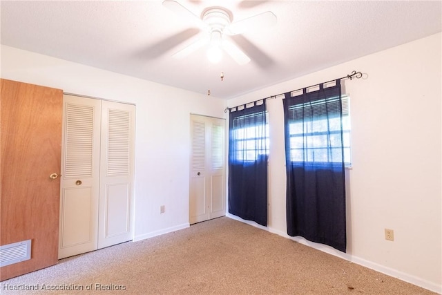 unfurnished bedroom with ceiling fan and carpet