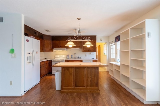 kitchen with white appliances, a center island, decorative light fixtures, dark wood-type flooring, and ceiling fan