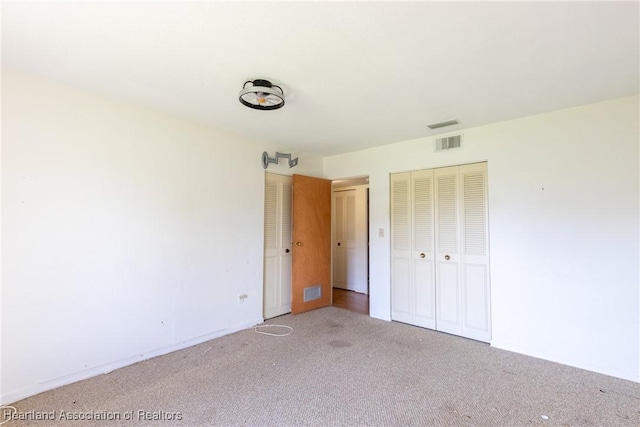 unfurnished bedroom featuring light colored carpet and a closet