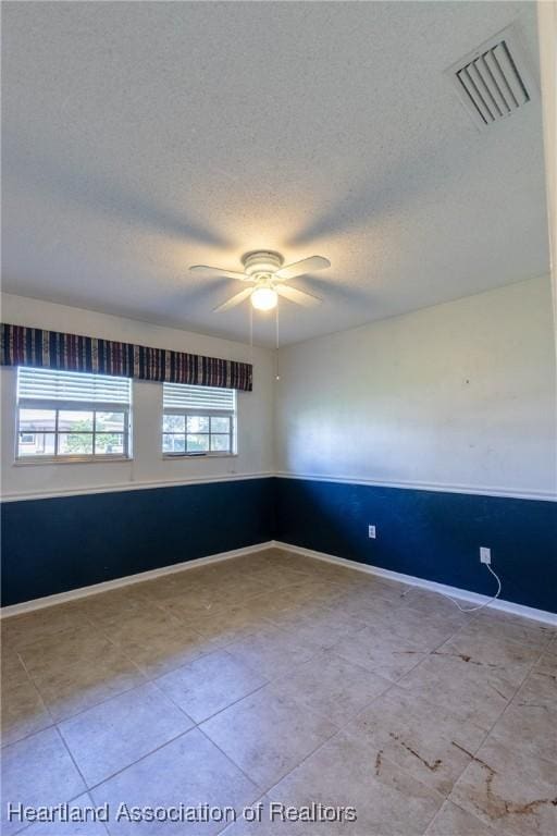 unfurnished room featuring a textured ceiling and ceiling fan