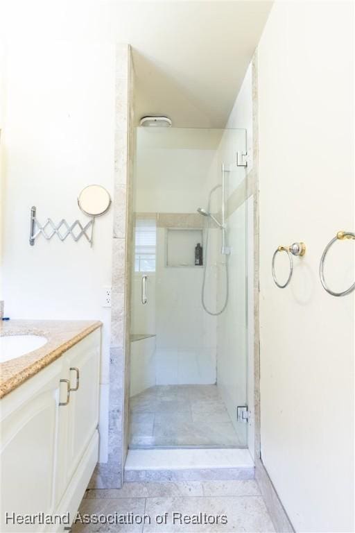 bathroom with a shower with door and vanity