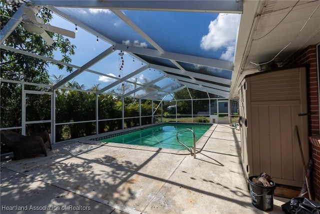 view of swimming pool with glass enclosure and a patio