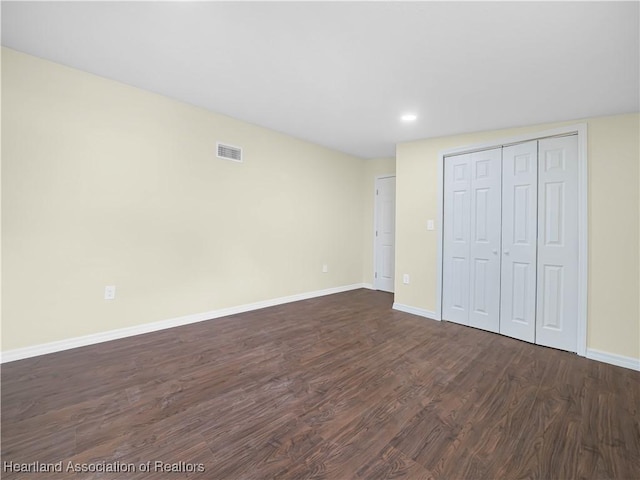 804 S 8th Ave, Wauchula, FL 33873 - unfurnished bedroom with a closet, visible vents, recessed lighting, dark wood-style floors, and baseboards