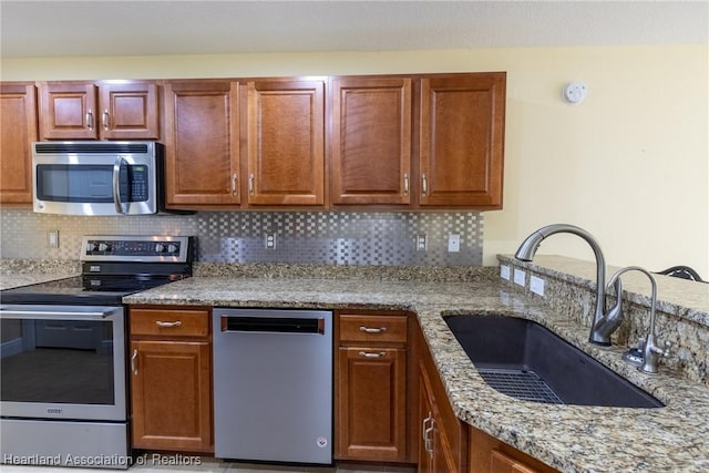 3108 Oakmont Dr, Avon Park, FL 33825 - kitchen with tasteful backsplash, appliances with stainless steel finishes, a sink, and light stone countertops