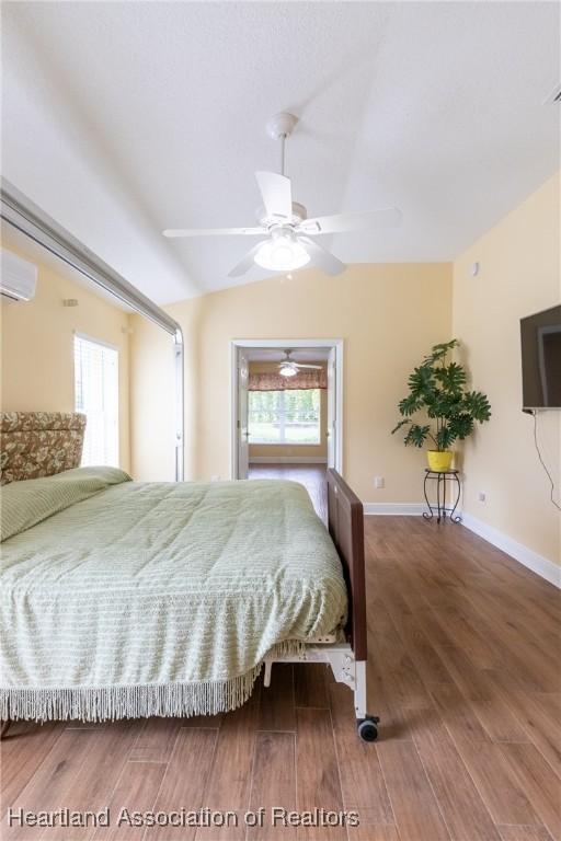 3108 Oakmont Dr, Avon Park, FL 33825 - bedroom with a wall mounted AC, wood finished floors, multiple windows, and lofted ceiling