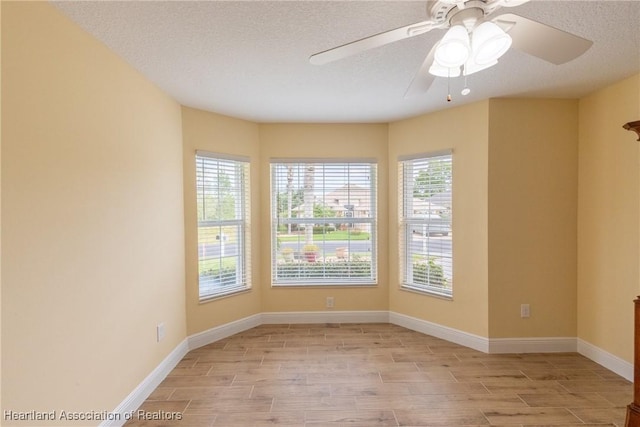 3108 Oakmont Dr, Avon Park, FL 33825 - spare room with baseboards, wood tiled floor, a ceiling fan, and a textured ceiling