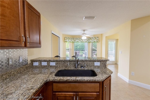 3108 Oakmont Dr, Avon Park, FL 33825 - kitchen featuring a peninsula, stone counters, visible vents, a sink, and backsplash