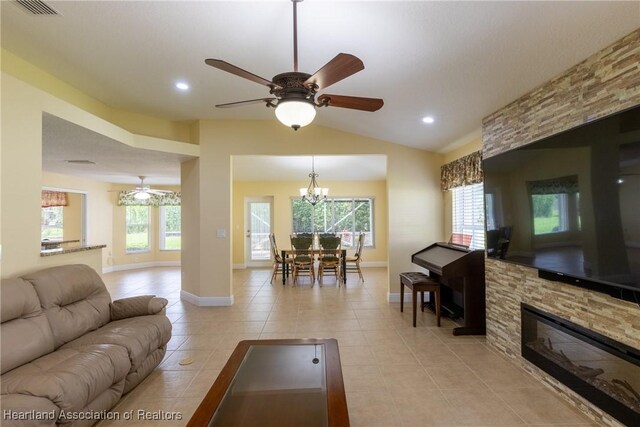 3108 Oakmont Dr, Avon Park, FL 33825 - living room featuring ceiling fan with notable chandelier, light tile patterned floors, baseboards, and lofted ceiling