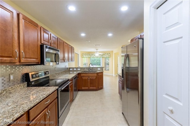 3108 Oakmont Dr, Avon Park, FL 33825 - kitchen with light tile patterned floors, a peninsula, a sink, stainless steel appliances, and backsplash