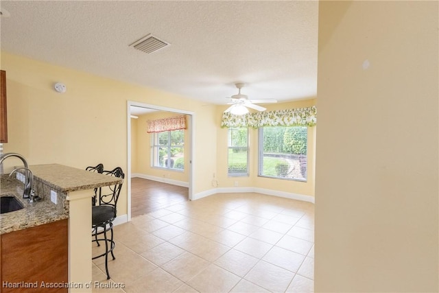 3108 Oakmont Dr, Avon Park, FL 33825 - interior space featuring ceiling fan, a kitchen breakfast bar, a textured ceiling, visible vents, and light stone counters