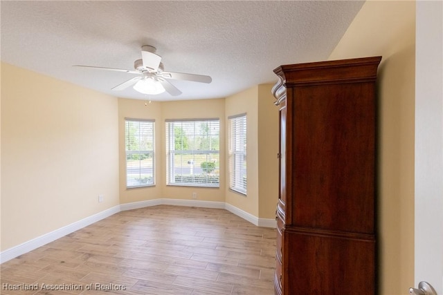 3108 Oakmont Dr, Avon Park, FL 33825 - unfurnished room with baseboards, light wood finished floors, ceiling fan, and a textured ceiling