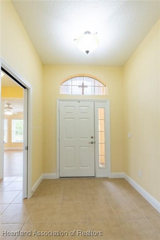 3108 Oakmont Dr, Avon Park, FL 33825 - foyer featuring light tile patterned floors, baseboards, and a textured ceiling