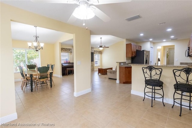 3108 Oakmont Dr, Avon Park, FL 33825 - kitchen with a wealth of natural light, visible vents, brown cabinets, stainless steel appliances, and ceiling fan with notable chandelier