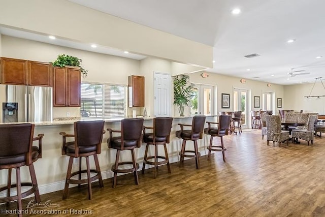 1624 Marble St, Sebring, FL 33870 - kitchen with stainless steel fridge, dark wood-style flooring, light countertops, recessed lighting, and a kitchen breakfast bar
