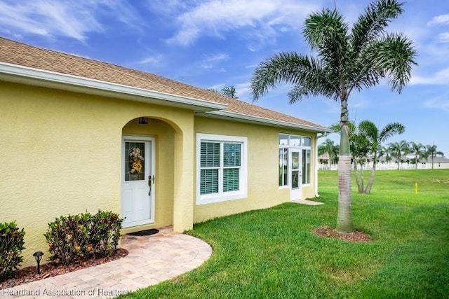 1624 Marble St, Sebring, FL 33870 - doorway to property with stucco siding and a lawn