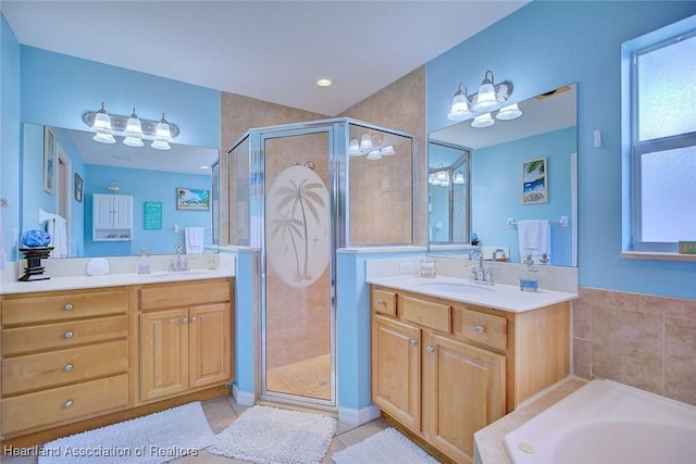 full bath with a stall shower, two vanities, a sink, and tile patterned floors