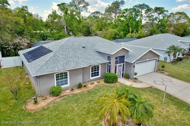 single story home with a garage, a shingled roof, fence, and a front lawn