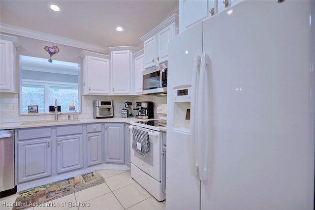 kitchen with light tile patterned floors, tasteful backsplash, stainless steel appliances, crown molding, and a sink