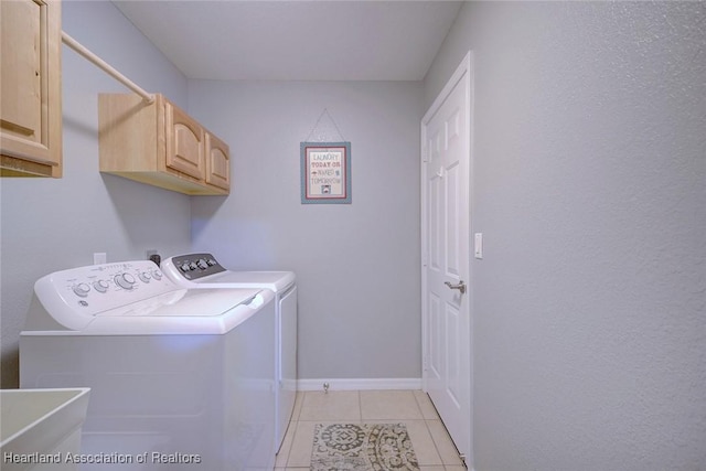 laundry room featuring light tile patterned flooring, a sink, baseboards, washer and dryer, and cabinet space