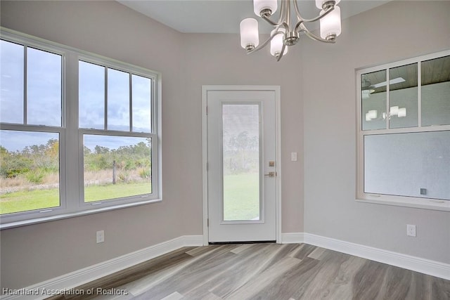 doorway to outside featuring hardwood / wood-style floors and an inviting chandelier