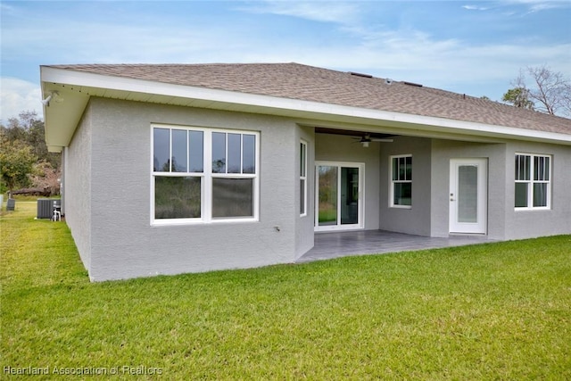 rear view of property featuring ceiling fan, a patio area, cooling unit, and a lawn