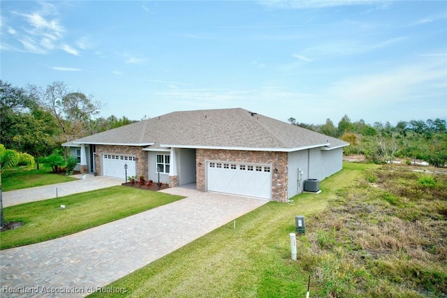 ranch-style house featuring a garage, a front yard, and central air condition unit