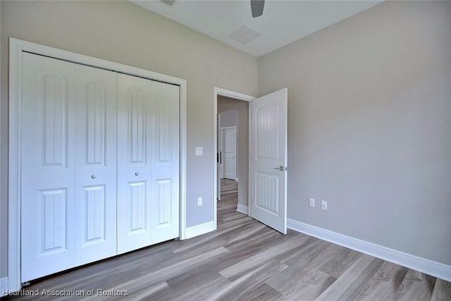 unfurnished bedroom featuring light hardwood / wood-style floors, a closet, and ceiling fan