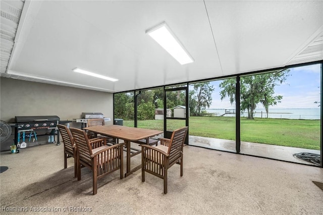 sunroom featuring a water view