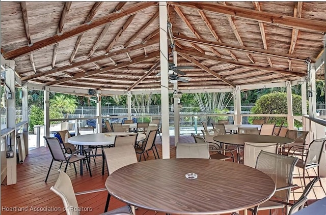 exterior space featuring a wealth of natural light, vaulted ceiling with beams, ceiling fan, and wooden ceiling