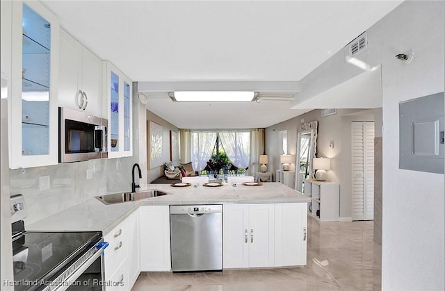 kitchen featuring white cabinets, sink, stainless steel appliances, and electric panel