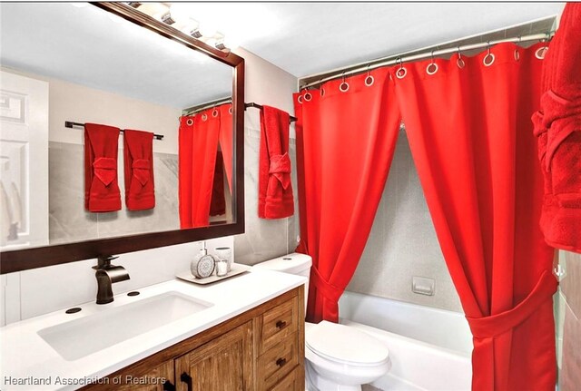 full bathroom featuring vanity, toilet, and shower / bathtub combination with curtain