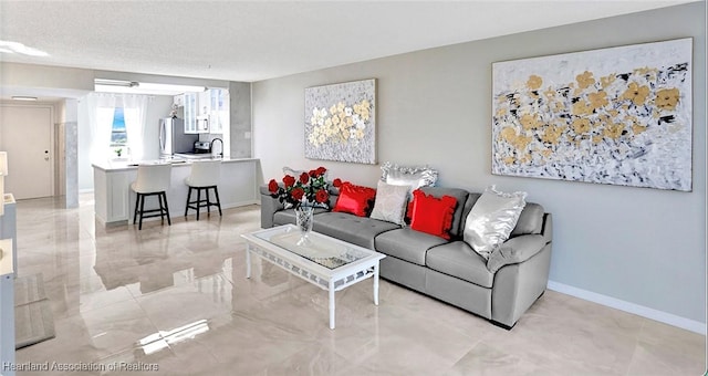 living room with a textured ceiling and sink