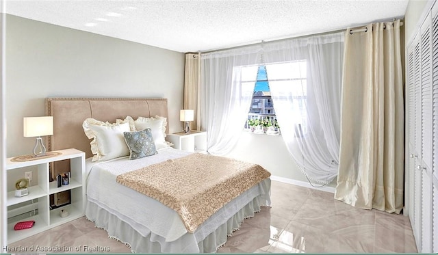 bedroom with a textured ceiling and a closet