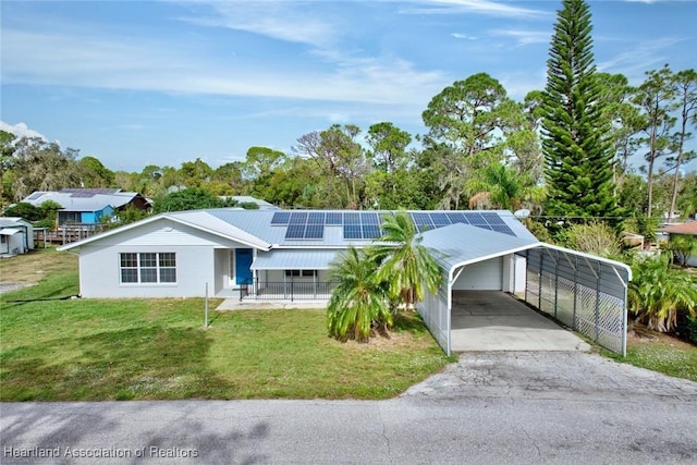 single story home featuring solar panels and a front lawn