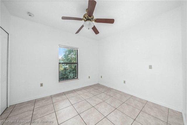 empty room with ceiling fan and light tile patterned flooring