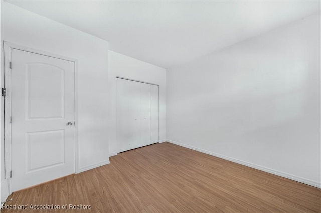 unfurnished bedroom with light hardwood / wood-style floors and a closet