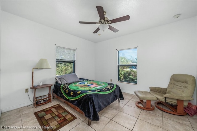 tiled bedroom with multiple windows and ceiling fan