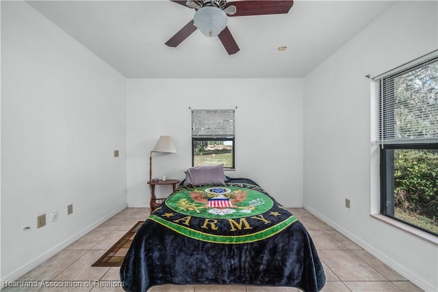 bedroom with multiple windows, ceiling fan, and light tile patterned flooring